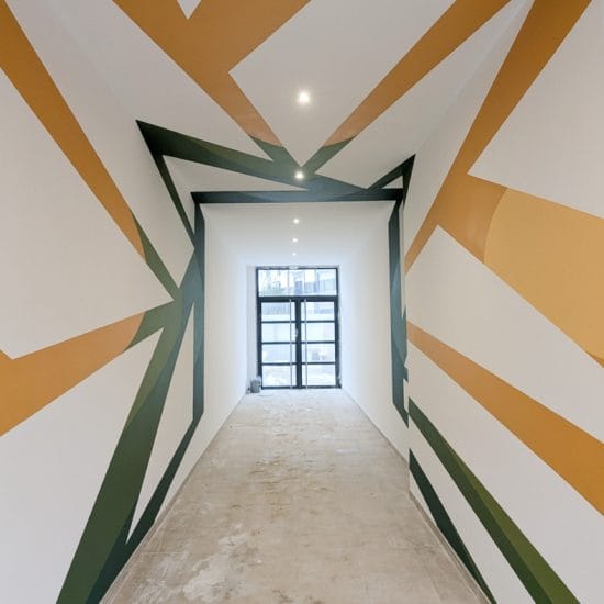 Détail peinture géométrique abstraite plafond et mur couloir résidence, palette ocre et vert forêt — peinture au plafond...
