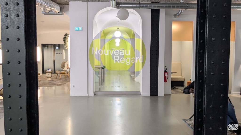 Anamorphose murale couloir bureau Paris, rosace jaune chartreuse et gris, lettrage Nouveau Regard