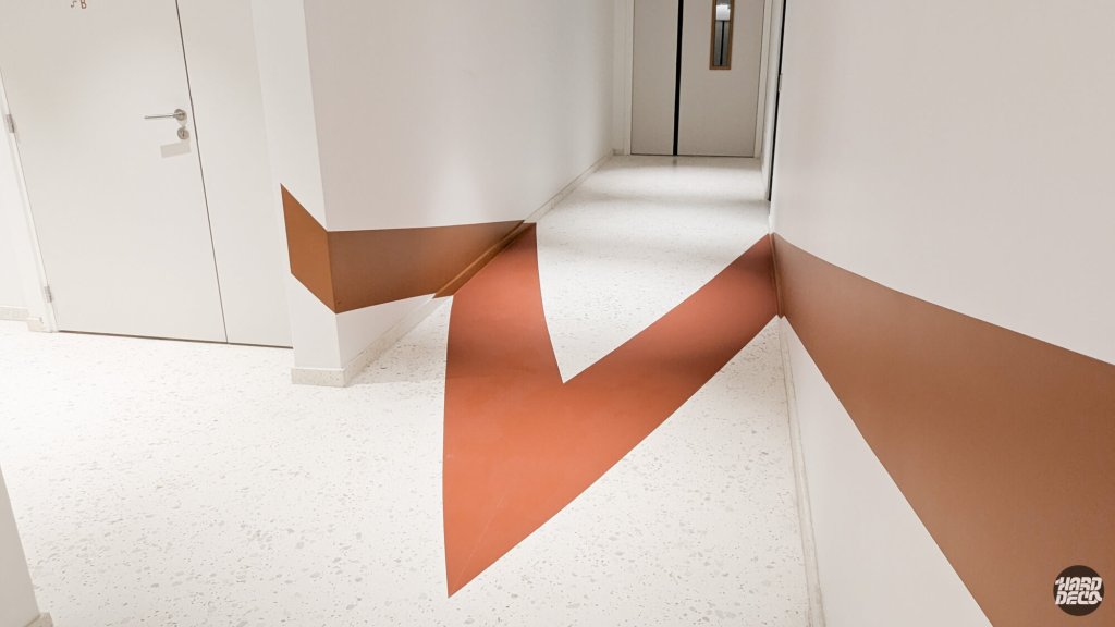 Détail anamorphose sol et mur couloir Warner Issy-les-Moulineaux, aplat terracotta angle rentrant