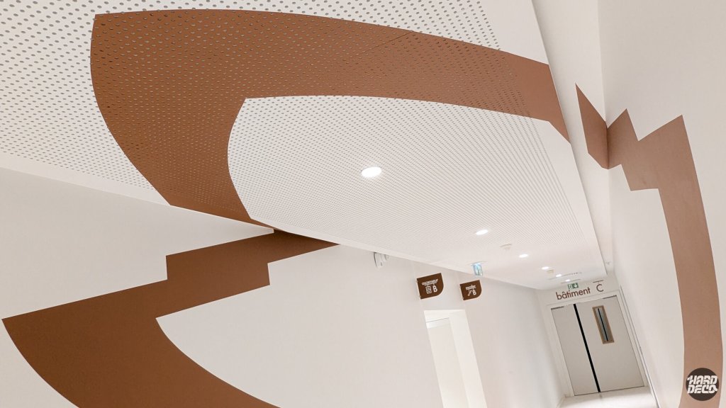 Anamorphose plafond perforé et mur couloir Warner Issy-les-Moulineaux, bandes terracotta pinceau rouleau