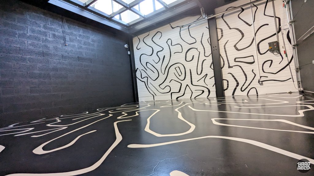 Fresque abstraite noir et blanc sur murs et sol d'un garage à Montevrain, tracés au pinceau
