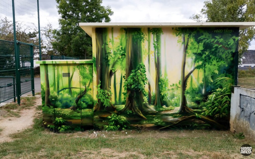 Fresque forêt sur local EDF, face latérale avec grands troncs et lumière dorée filtrante, aérosol plein air