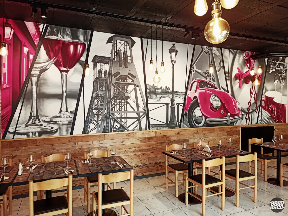 Toile aérosol restaurant Charleroi : décor rétro Coccinelle rouge et rouages sur fond gris, vue salle complète