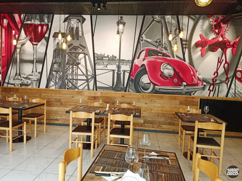 Vue d'ensemble toile aérosol restaurant Charleroi : Coccinelle rouge, pont et rouages en contraste noir et blanc