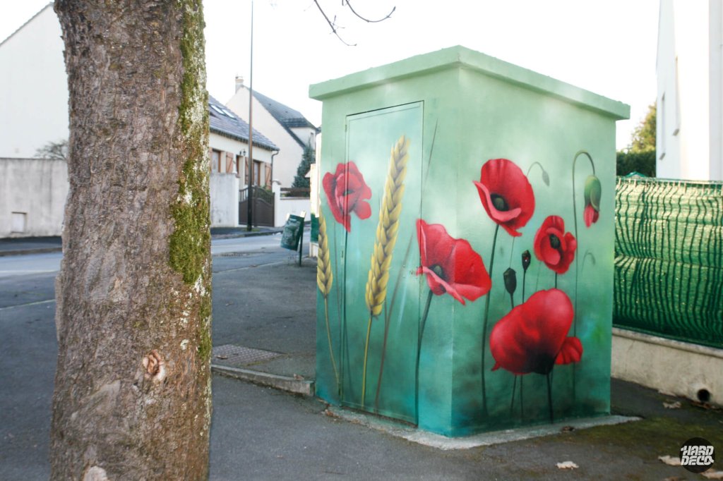 Armoire électrique avec coquelicots rouges et épi de blé sur fond vert turquoise, rue de Villevaudé