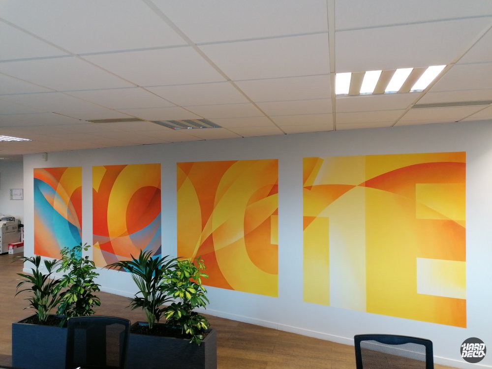 Toiles aérosol abstraites aux couleurs orange et jaune avec typographie Cogeferm dans un open space