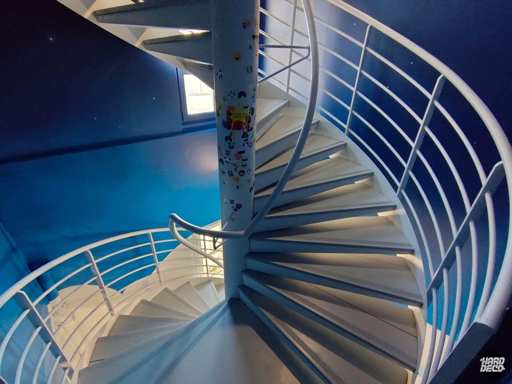 Vue plongeante de la cage d'escalier hélicoïdale peinte en bleu nuit avec étoiles, Paris