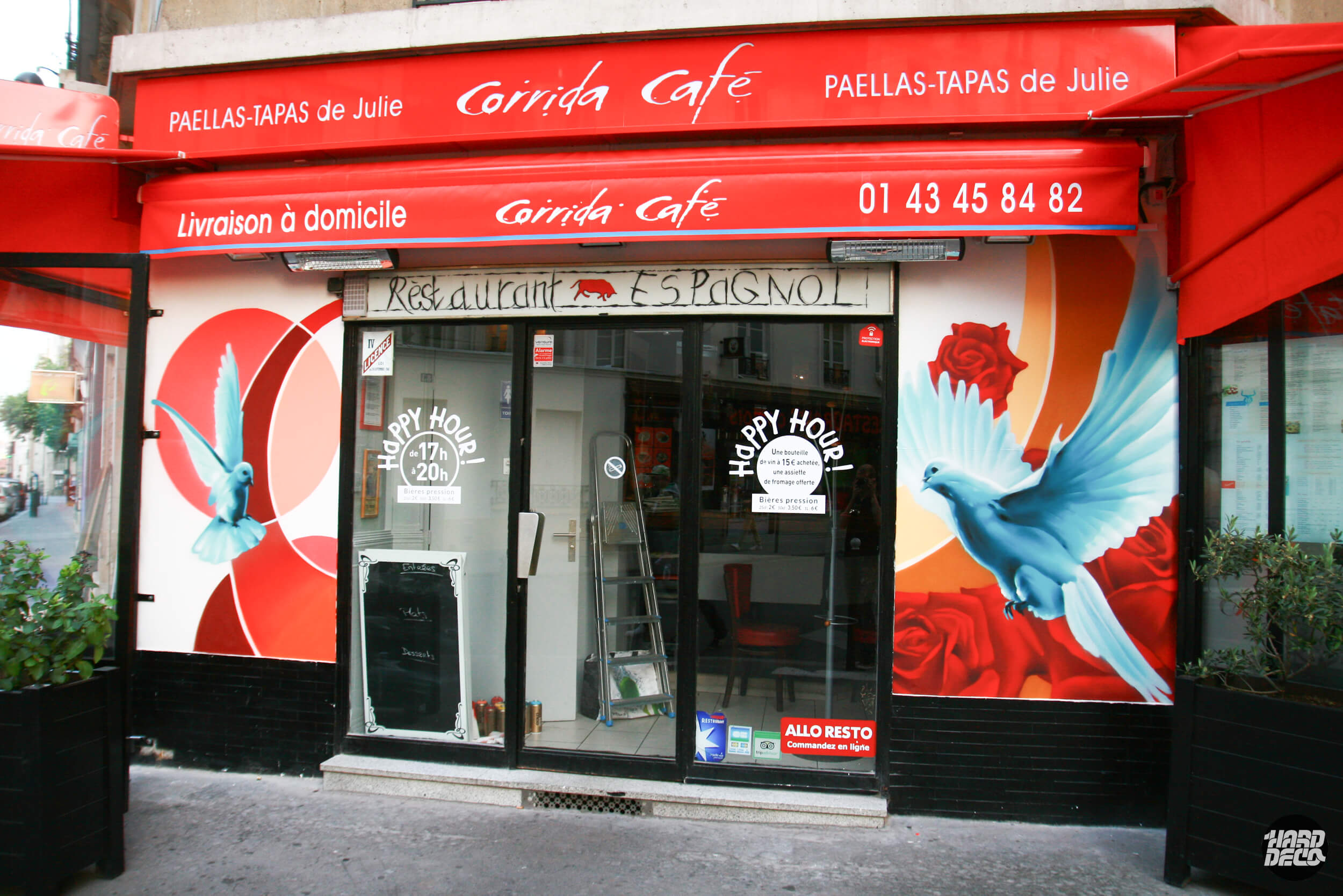 Façade du Corrida Café Paris avec fresques aérosol : colombes turquoise et roses rouges sur fond orange