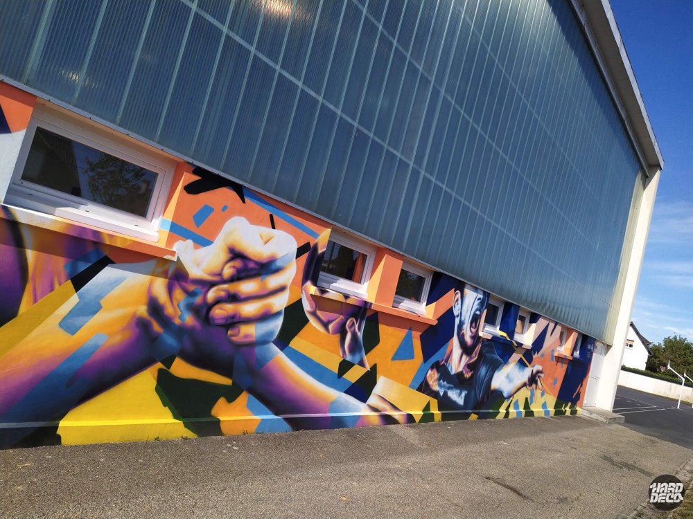 Fresque extérieure gymnase Pontault-Combault, mains entrelacées et sportif en action, palette jaune orange