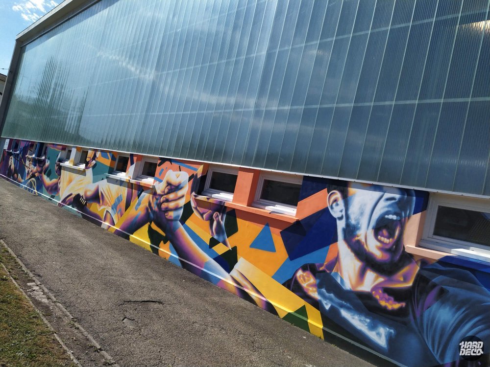 Fresque aérosol façade gymnase Pontault-Combault, joueur de sport et formes géométriques orange et bleu