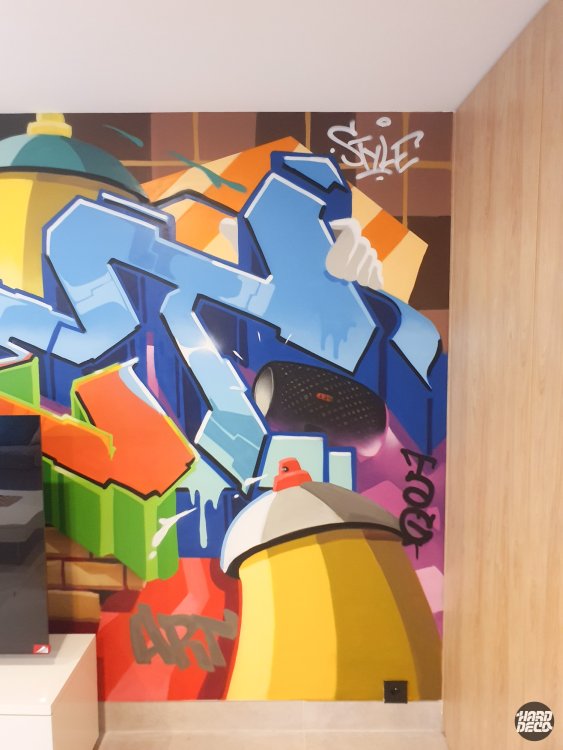 Détail fresque graffiti hip-hop, bombe aérosol jaune et rouge géante, lettrage bleu avec tag Style en haut