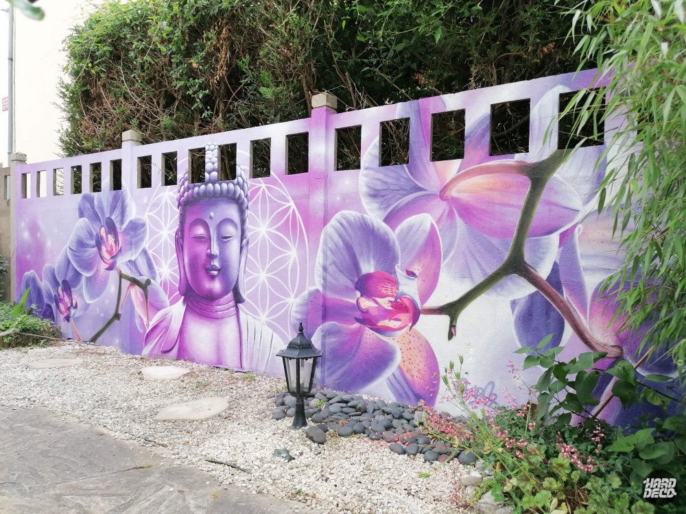 Fresque aérosol Bouddha fleur de vie et orchidées mauve sur mur extérieur, vue de face
