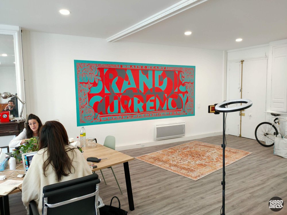Vue d'ensemble bureaux Brain & Heart Paris fresque murale street art slogan Brand is Currency