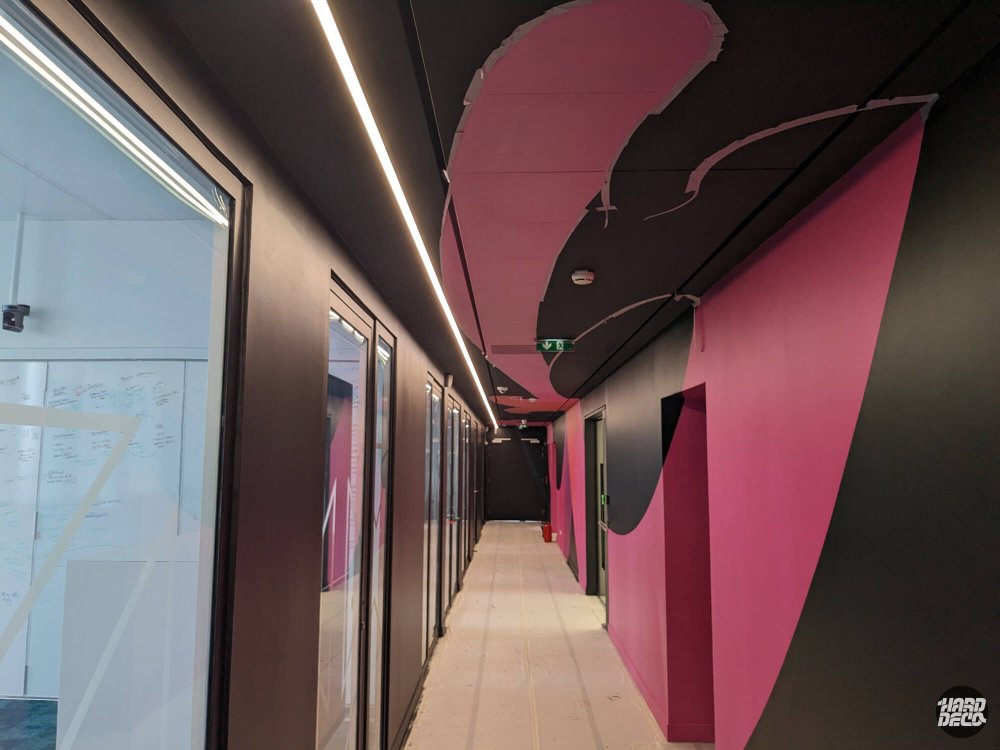 Couloir sombre bureaux TCS avec décor mural et plafond peint en noir anthracite et magenta, en chantier