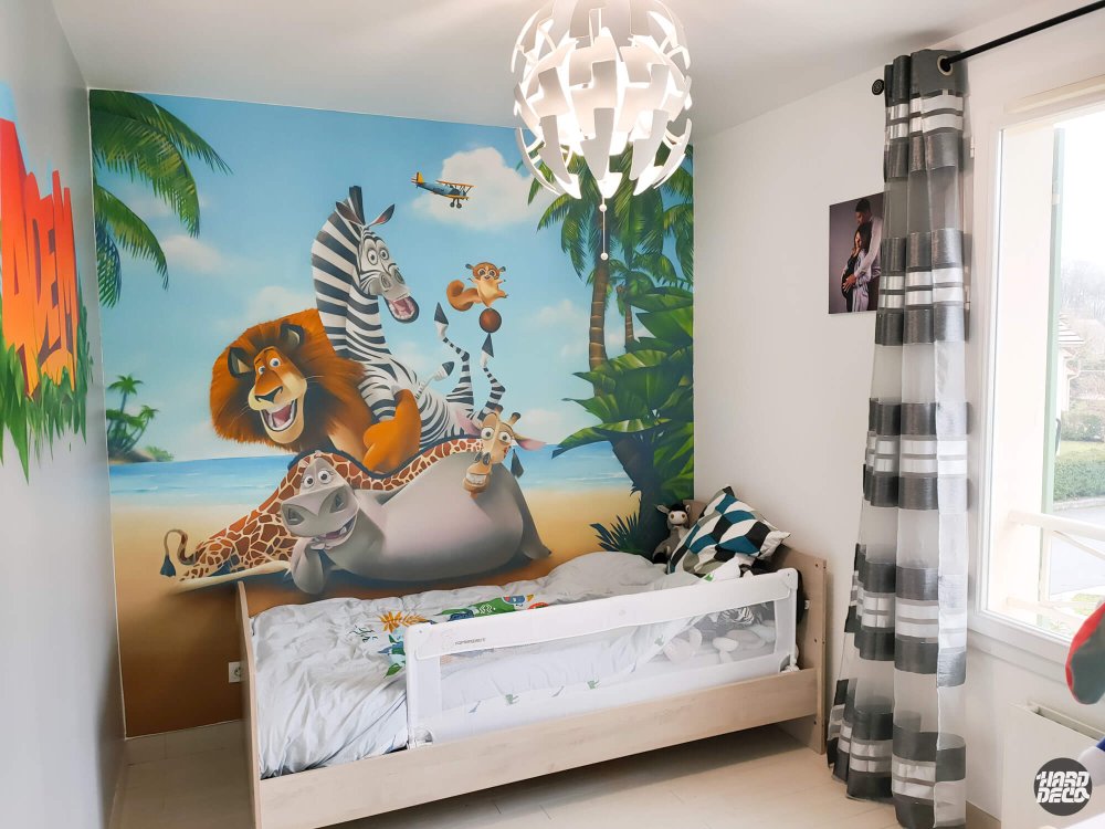 Fresque Madagascar chambre enfant, scène plage tropicale avec Alex et Marty, ambiance lumineuse