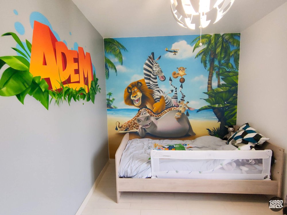 Fresque Madagascar et prénom Adem en graffiti orange sur mur adjacent, chambre enfant vue d'angle