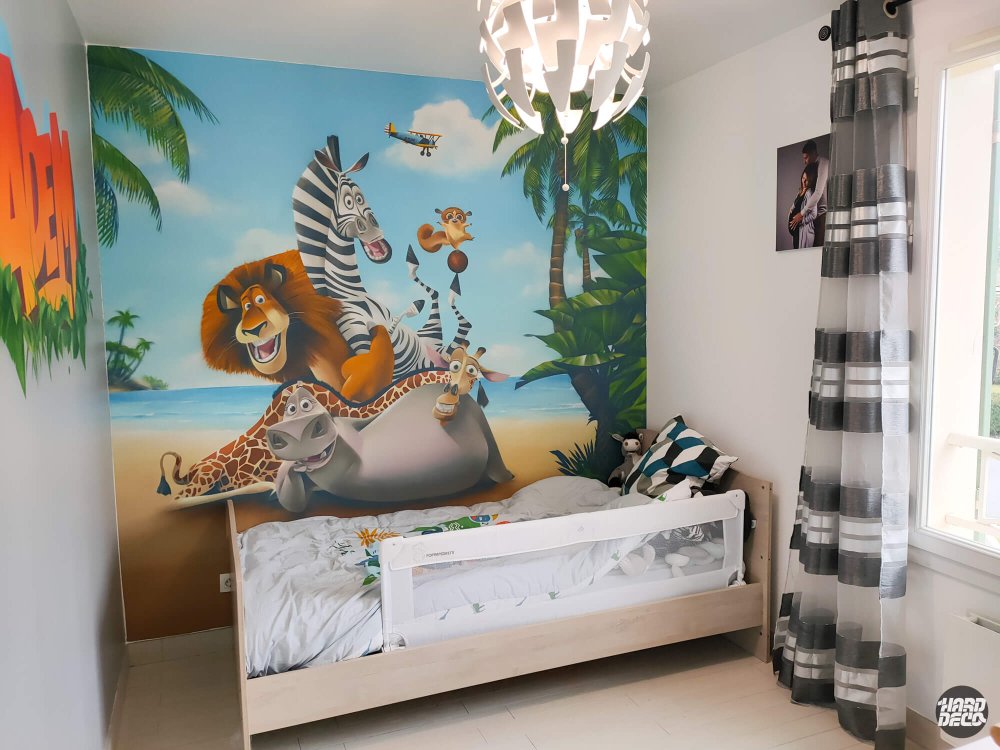 Fresque Madagascar chambre enfant avec lion, zèbre, girafe et hippopotame sur plage tropicale, vue d'ensemble