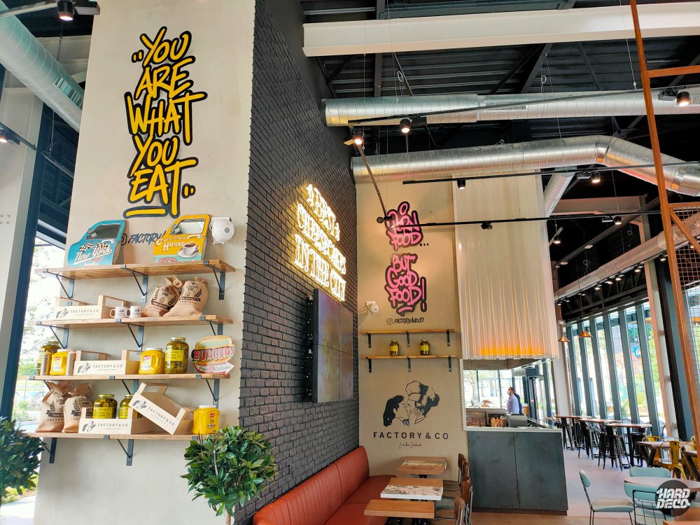 Lettrage You Are What You Eat en jaune et textes graffiti peints sur pilier et mur Factory & Co