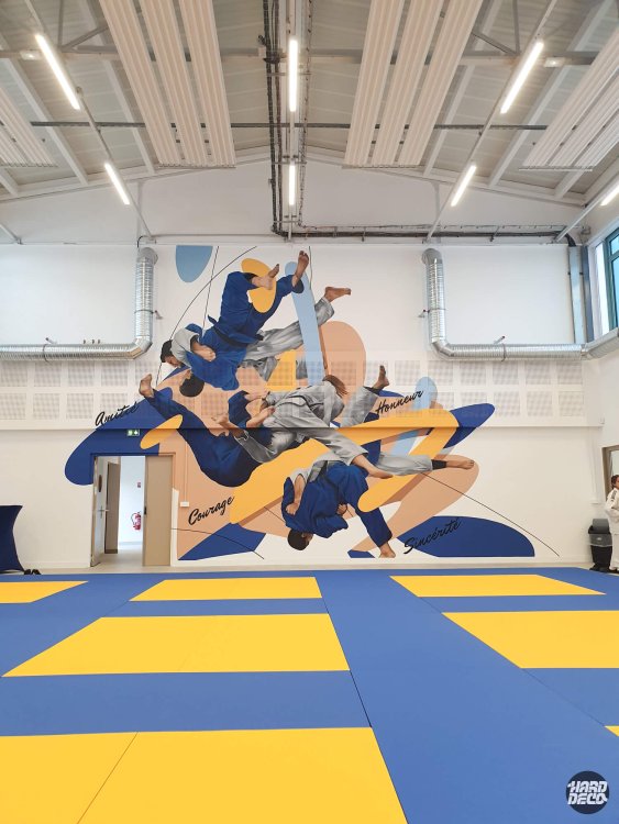 Fresque murale judo dojo Combs-la-Ville, judokas en kimono bleu et gris projetés sur fond doré et bleu marine
