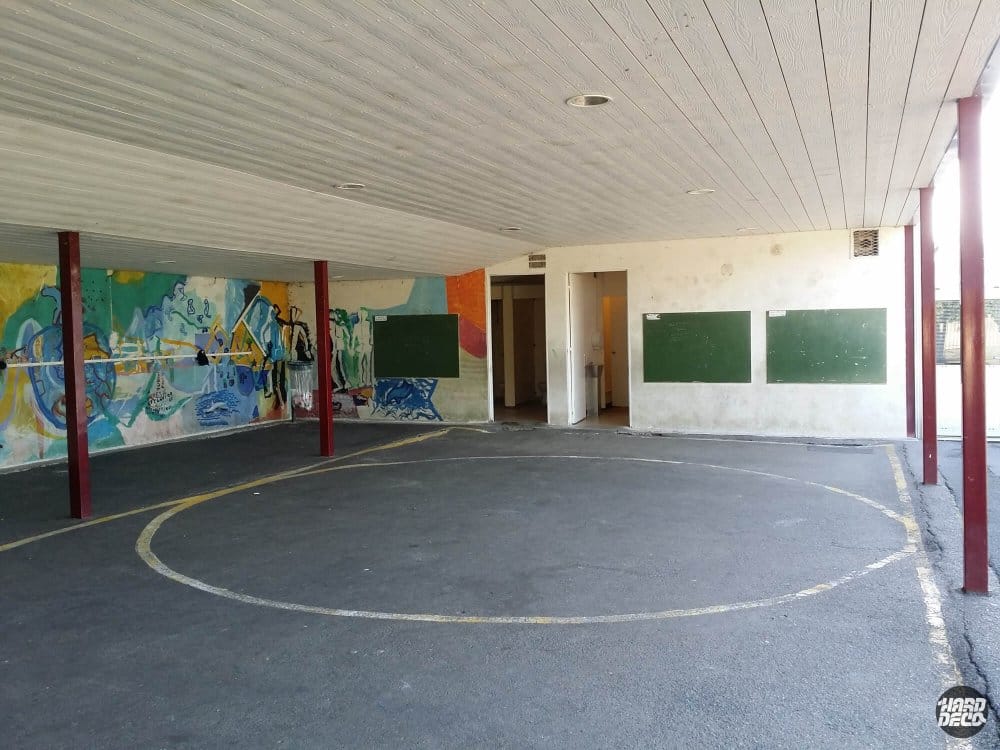 Vue avant travaux du préau de l'École des Noyers, murs dégradés avec ancienne peinture délavée