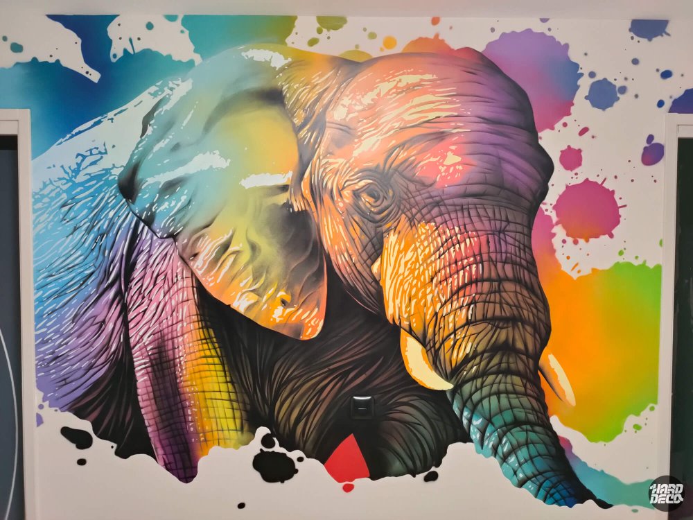 Portrait d'éléphant coloré en aérosol sur mur blanc, détail rapproché, palette orange violet cyan