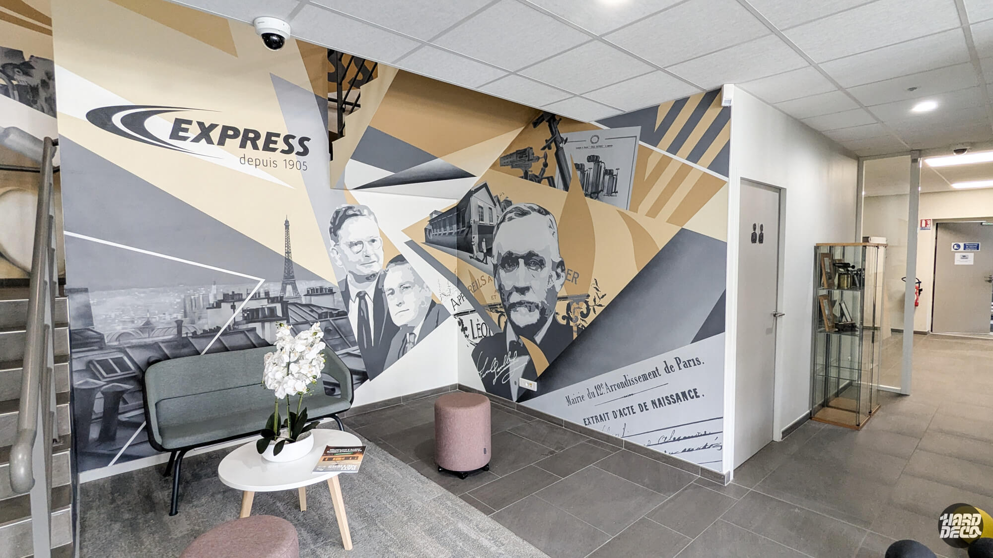 Fresque murale Express 120 ans dans le hall d'accueil, portraits en grisaille et géométrie dorée
