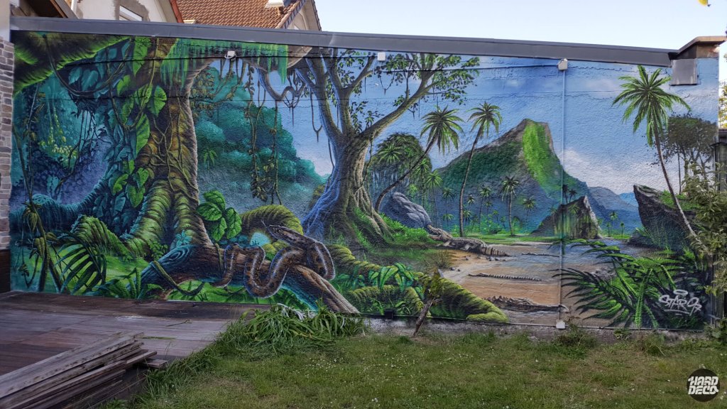 Fresque jungle sur mur extérieur, vue frontale complète avec boa au premier plan et palmiers, peinture aérosol