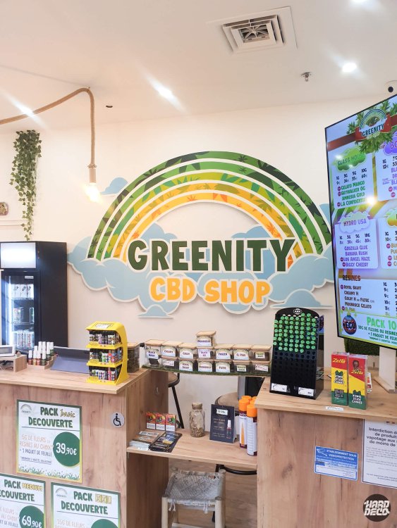 Détail fresque arc-en-ciel Greenity CBD Shop, lettrage jaune et bandes feuilles stylisées aérosol