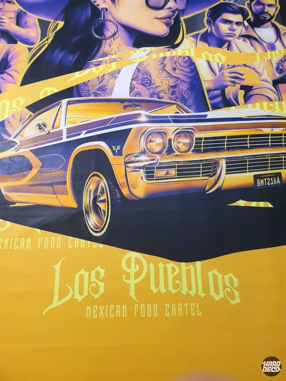 Détail lowrider Chevrolet doré et typographie Los Pueblos Mexican Food Cartel sur fresque aérosol