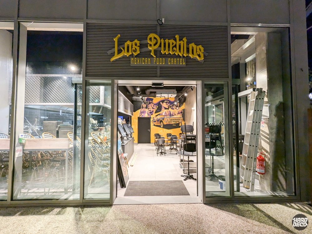 Entrée du restaurant Los Pueblos Grenoble de nuit, fresque visible depuis la vitrine extérieure