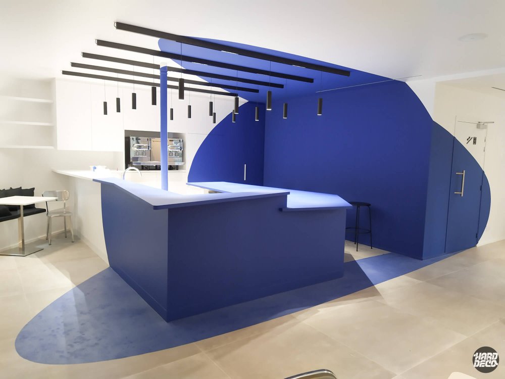 Anamorphose bleue sur comptoir d'accueil hôtel Graphik Montparnasse, fresque géométrique bleu cobalt