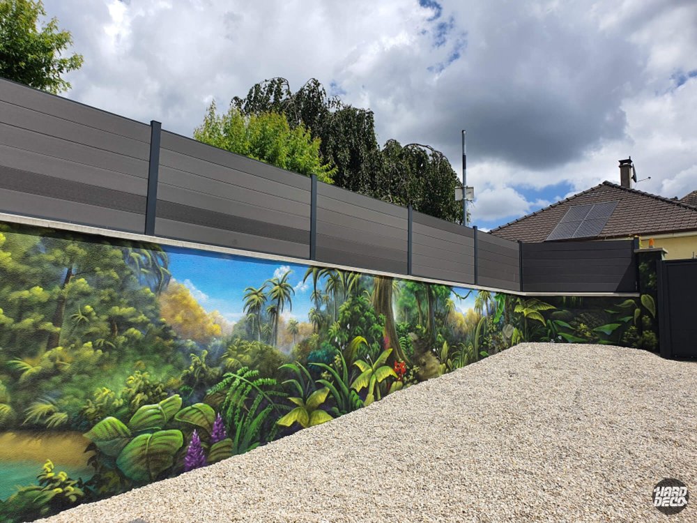Fresque murale jungle tropicale sur clôture extérieure, angle droit, végétation dense et ciel nuageux