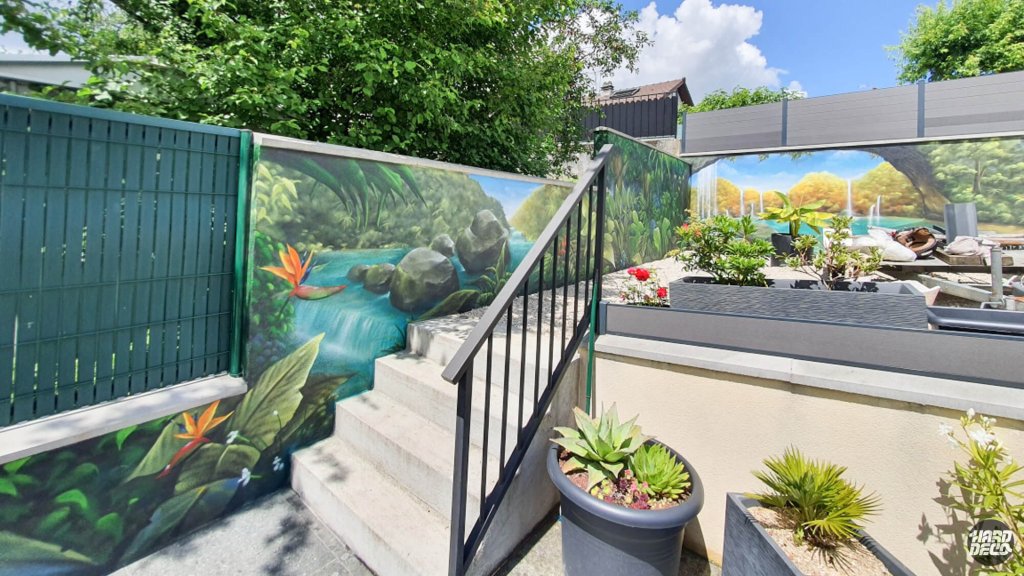 Fresque extérieure jungle avec strelitzias orange et cascade, vue depuis l'escalier du jardin