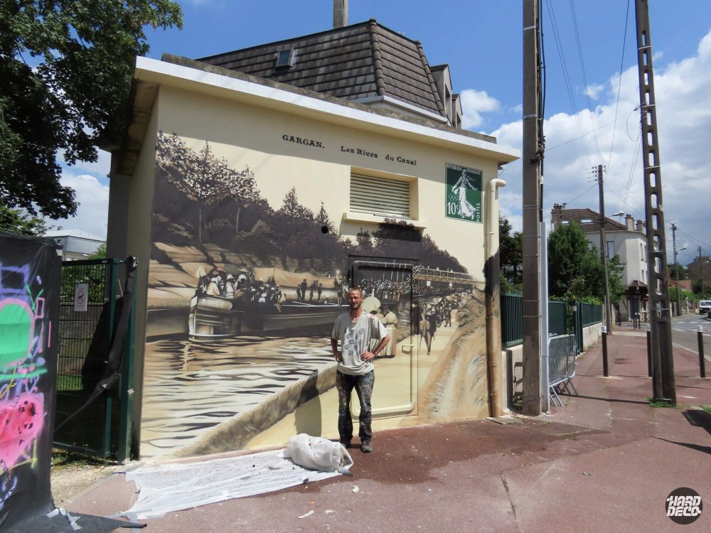Vue d'ensemble fresque façade Livry-Gargan avec artiste au premier plan, scène sépia rives du canal
