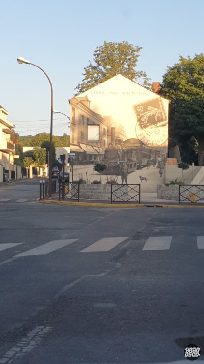 Fresque murale façade Livry-Gargan, carte postale ancienne sépia avec locomotive à vapeur, vue depuis la rue au coucher du soleil