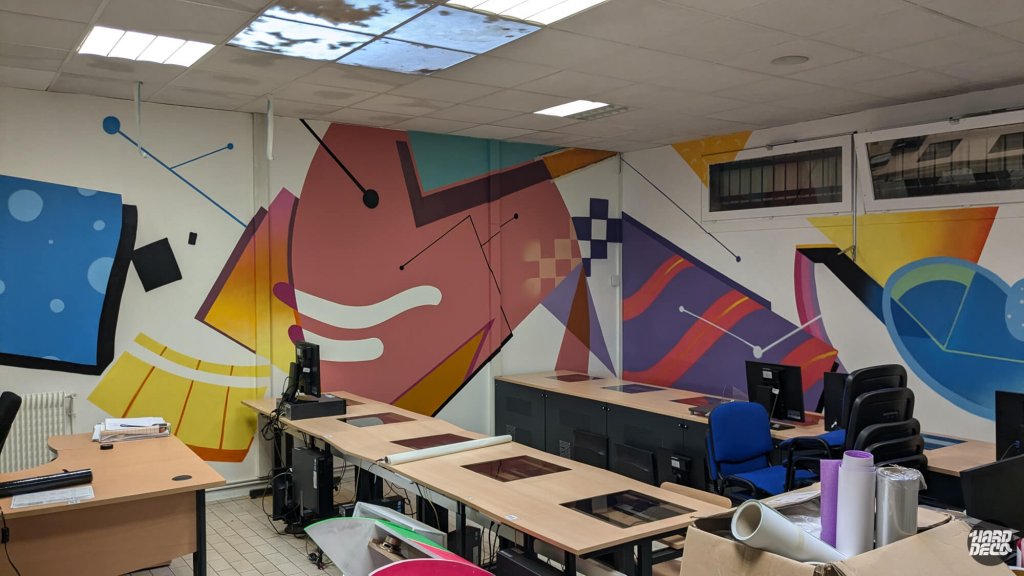 Fresque murale abstraite salle de travail Montfermeil, formes géométriques rose mauve jaune orange et fils noirs, vue salle