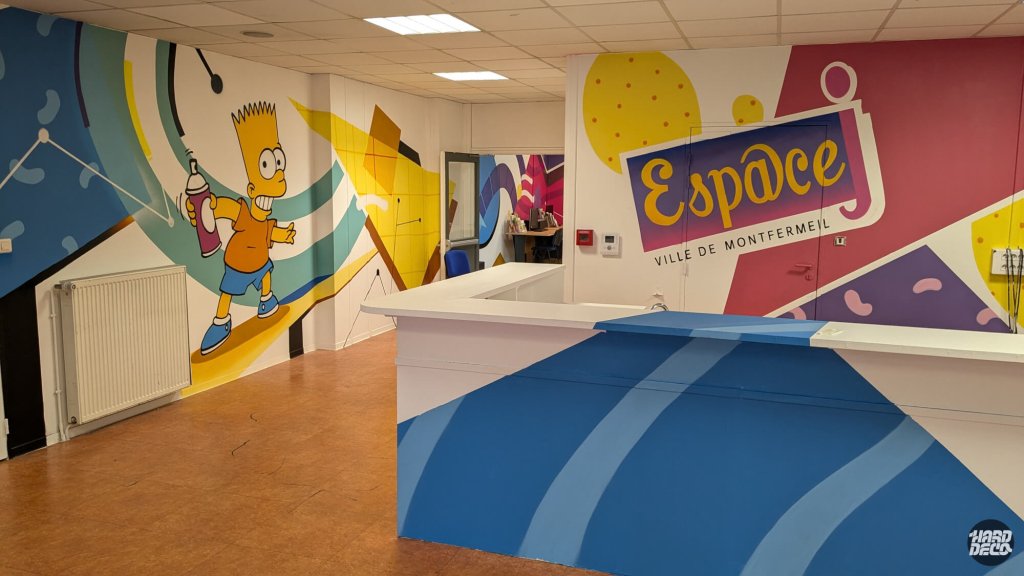 Fresque Bart Simpson et logo Espace Ville de Montfermeil, décor mural pop coloré comptoir accueil jeunesse