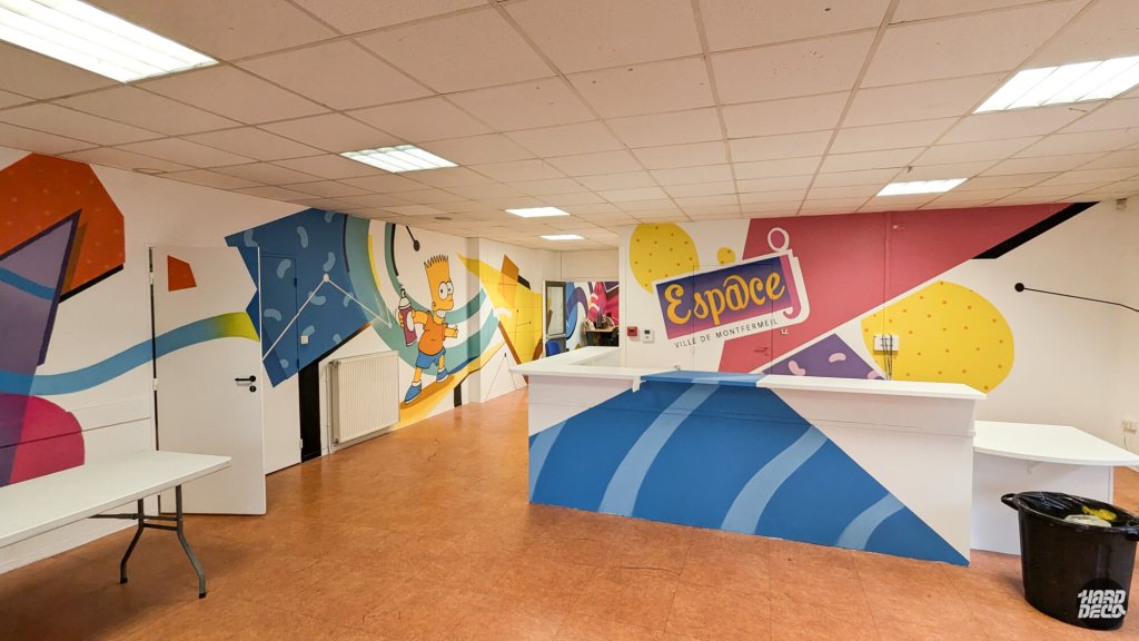 Vue panoramique fresque murale Espace Jeunesse Montfermeil, Bart Simpson bombe à la main, logo municipal, décor géométrique 110m²