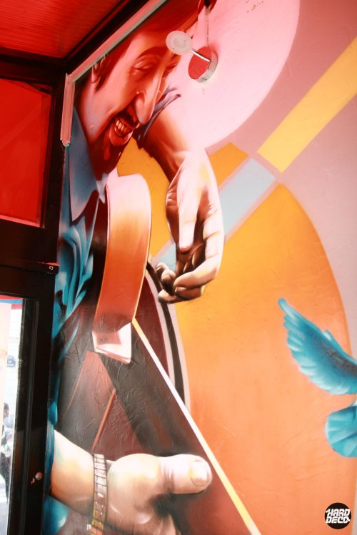 Fresque aérosol Corrida Café Paris : portrait hyperréaliste guitariste espagnol sur montant d'entrée