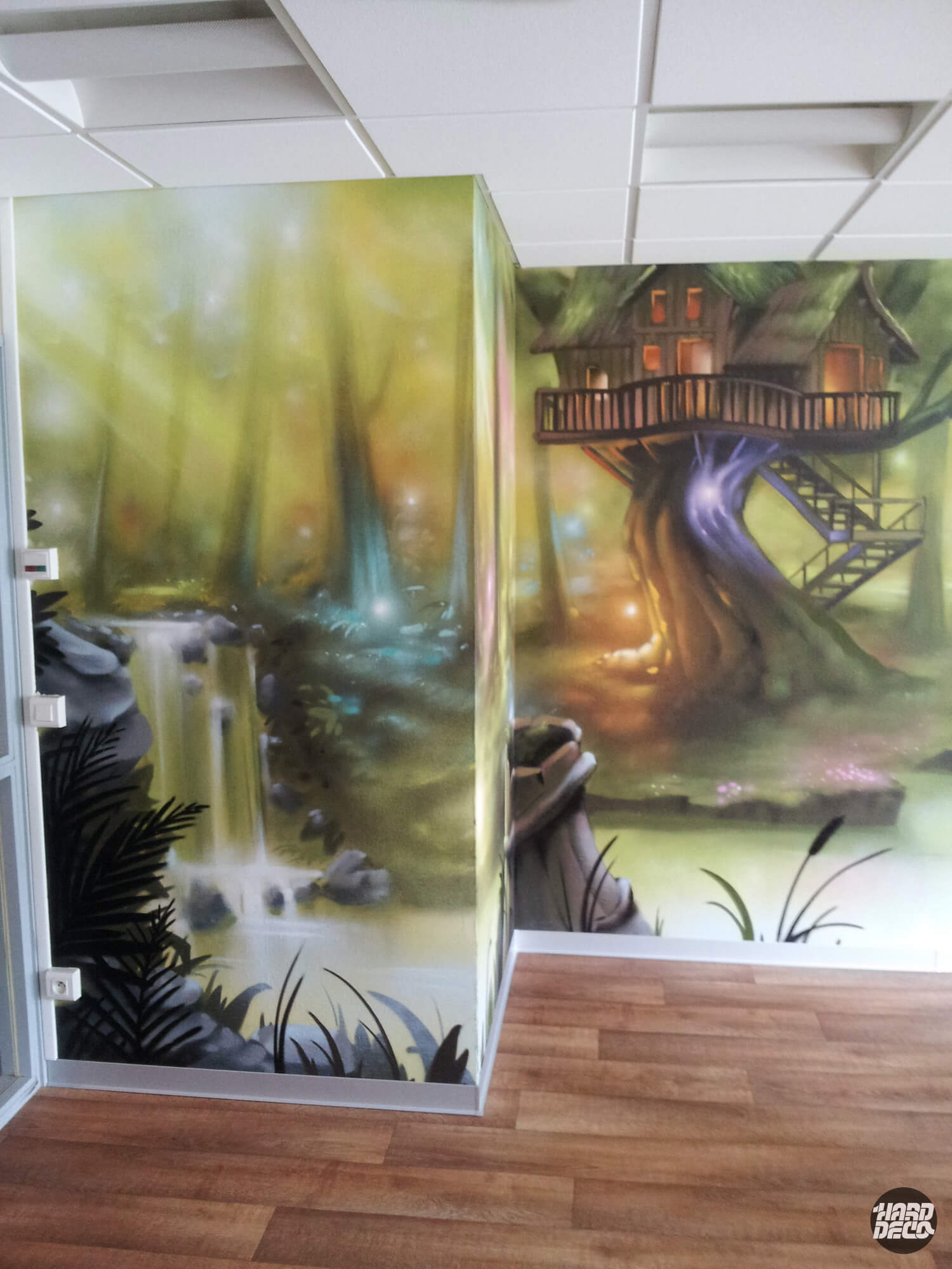 Fresque murale forêt magique avec cascade et cabane dans les arbres, clinique Paris 16e