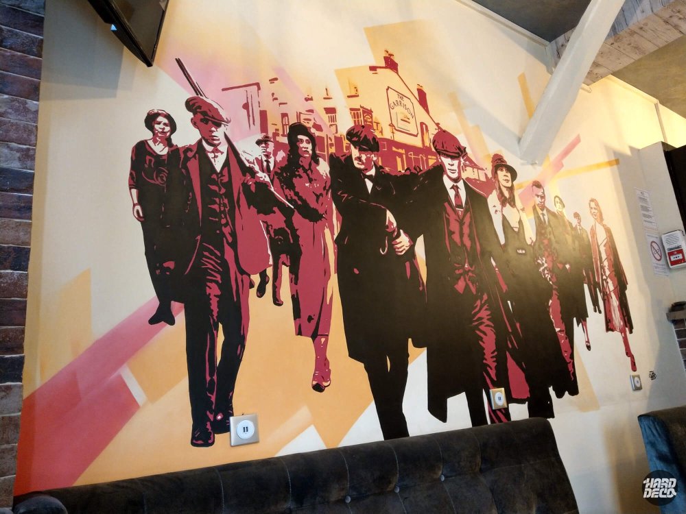 Détail fresque Peaky Blinders bar Paris, silhouettes famille Shelby en aplats bordeaux et noir