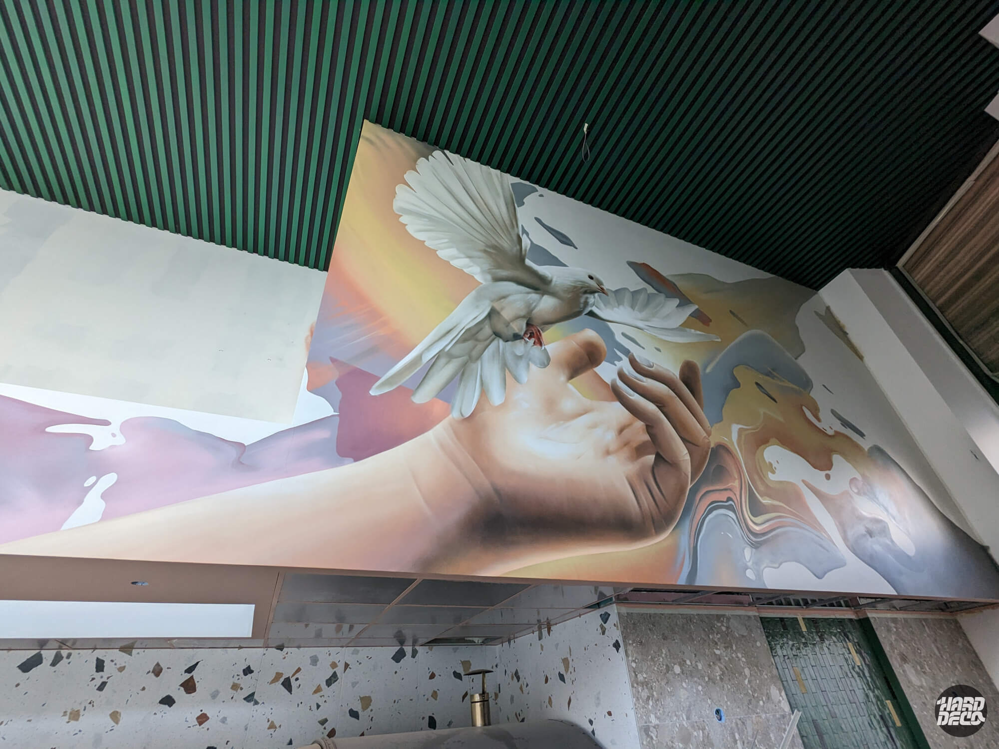 Fresque murale aérosol restaurant Paris 13e, main libérant une colombe blanche sur fond doré et nacré