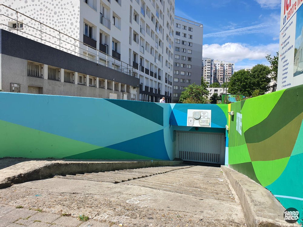 Accès parking collectif résidence 3F fresques teal et vert géométriques sur murets béton extérieur