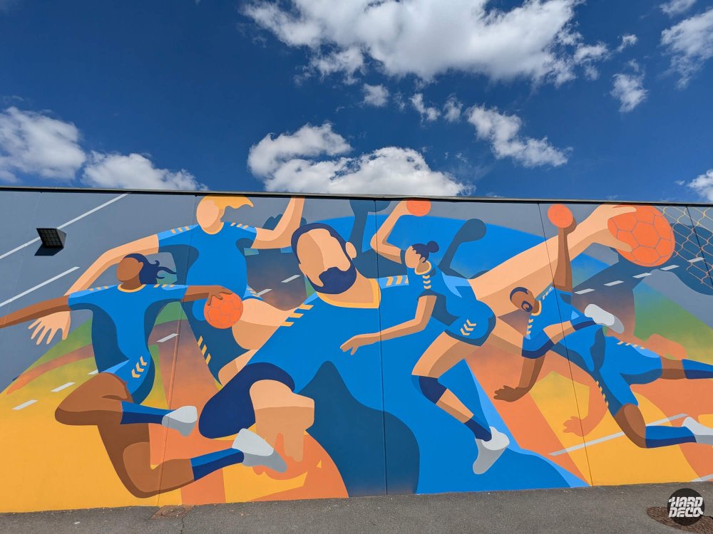 Gros plan fresque handball Pontault-Combault, personnages en maillot bleu cobalt avec ballon orange et filet