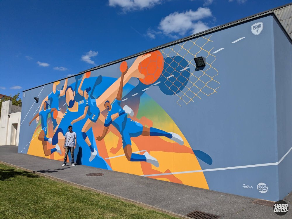 Vue d'ensemble fresque handball 54 m² façade gymnase Pontault-Combault avec artiste Shero et logo PCHB