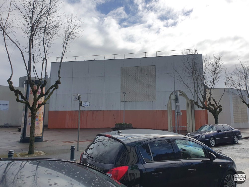 Vue d'ensemble de la façade vierge du gymnase Bois Ramé avant la réalisation de la fresque JO 2024