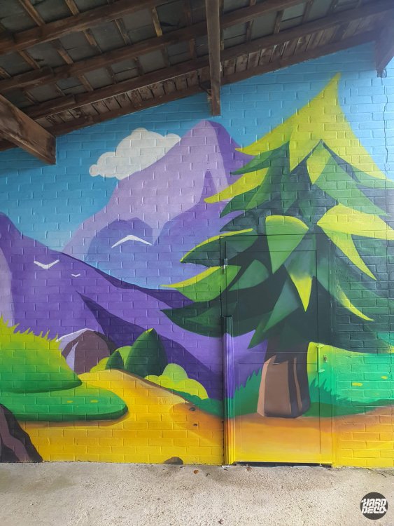 Détail fresque aérosol préau école Torcy, montagne violette et sapin vert sur parpaing, gros plan