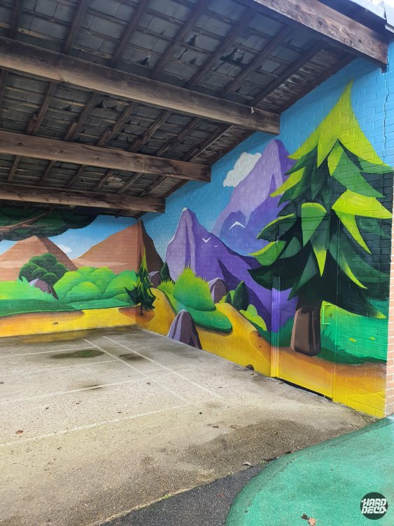 Détail fresque aérosol préau Torcy, grand sapin vert citron et montagne violette sur parpaing