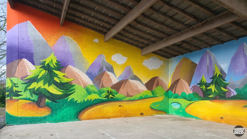 Fresque murale école Torcy, paysage montagne coloré ciel jaune orangé avec sapins, vue mur extérieur