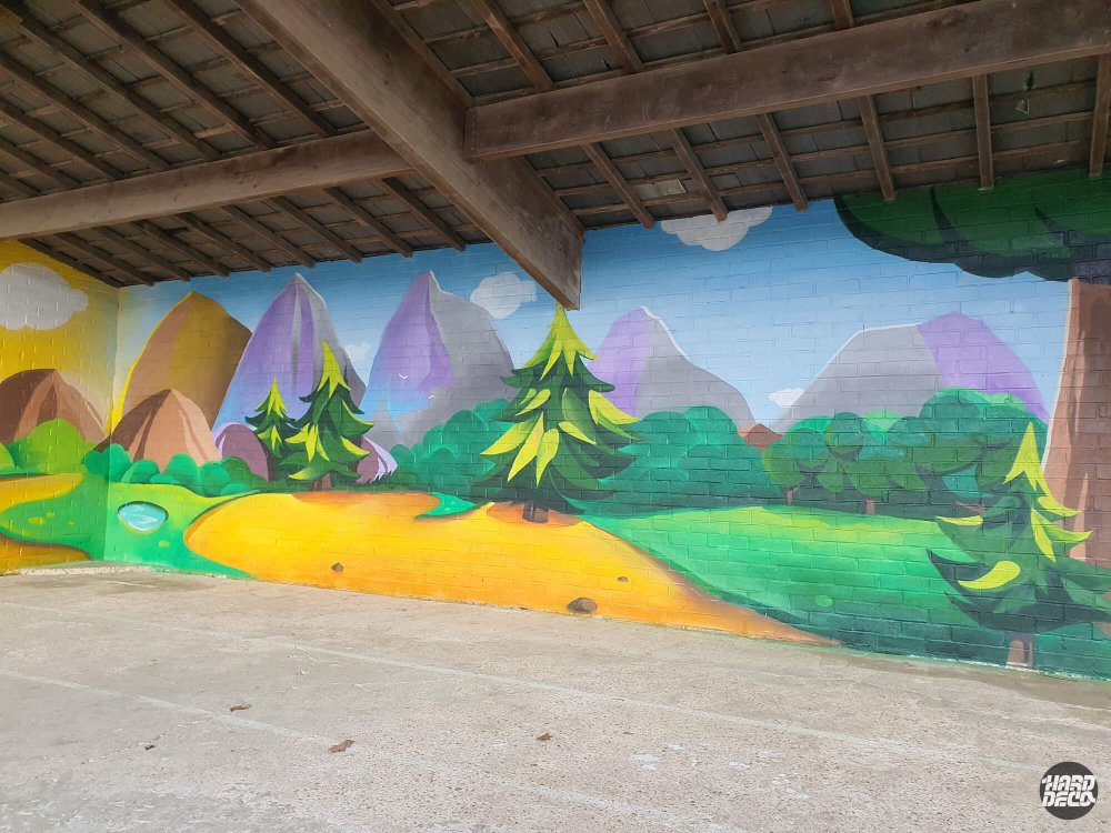 Fresque murale préau Torcy, paysage de montagne aux tons lavande et vert, sapins et prairies dorées